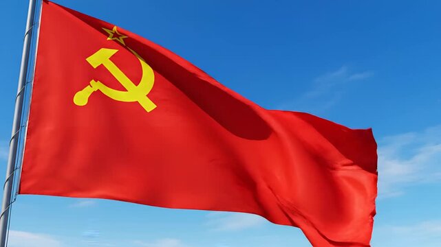 Red flag with hammer and sickle symbol waving in blue sky.