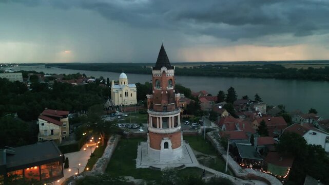 Aerial orbit of Gardos Tower with massive lightning storm over Danube river behind, Belgrade, Serbia.