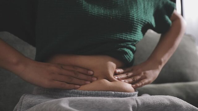 Overweight woman body with hands touching belly fat