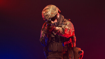 Naklejka premium Soldier holding position on blurred red and blue gradient background. Concept strength and readiness. 