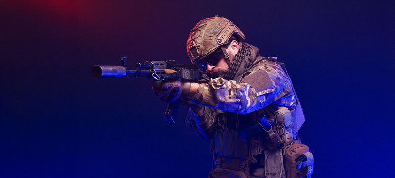 Armed forces soldier on abstract red-blue blur background. Concept duty, protection and resilience.
