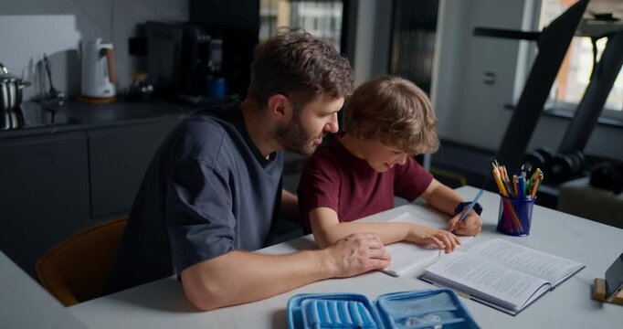 White Father Guiding Son Through Workbook Problem Close Proximity Pointing Steady Patience