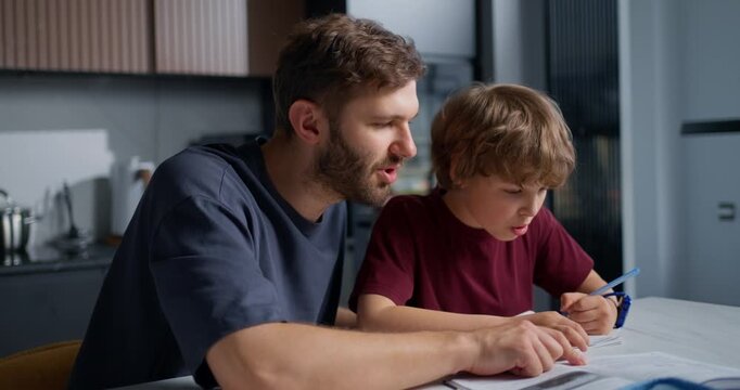 Father Guides Learning. Father Thoughtfully Assists Son With Problem Solving In Kitchen Environment