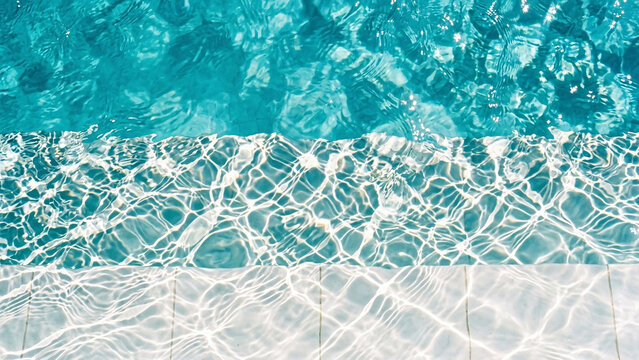 Clear turquoise swimming pool water texture with caustic light reflections.