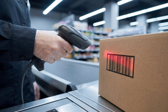 A retail counter view shows a handheld barcode scanner scanning a box during package intake. The scene emphasizes parcel processing and reader use at a service counter.