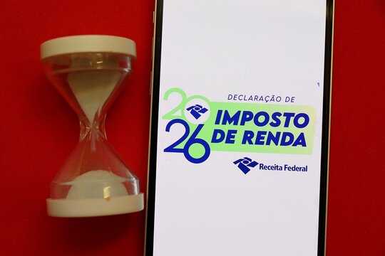 S&atilde;o Paulo, Brazil - April 29, 2026: Declara&ccedil;&atilde;o de Imposto de Renda 2026 (Brazilian Income Tax 2026) logo on a screen next to an hourglass. Deadline approaching.