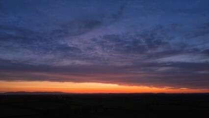 Obraz premium Colorful sunset horizon over dark rural landscape silhouette