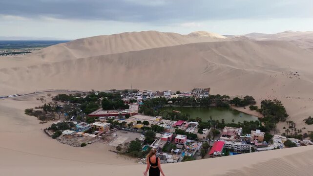 Aerial view of a serene Peruvian town amidst vast sand dunes