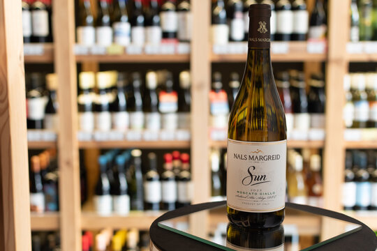 Bottle of Nals Margreid Sun Moscato Giallo Alto Adige DOC white wine on a mirror surface in a wine store with blurred shelves of bottles in background. Ukraine, Zhytomyr, April 28, 2026