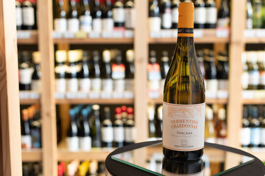 Bottle of Tenuta Montecchiesi Vermentino Chardonnay Toscana IGT white wine on a mirror surface in a wine store with blurred shelves in the background. Ukraine, Zhytomyr, April 28, 2026