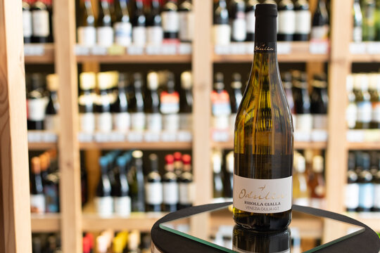 Bottle of Odulin Ribolla Gialla Venezia Giulia IGT white wine on a mirror surface in a wine store with blurred shelves of bottles in the background. Ukraine, Zhytomyr, April 28, 2026