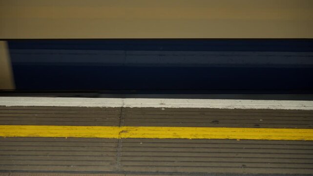 Train approaches platform at subway station during afternoon hours in a busy urban area