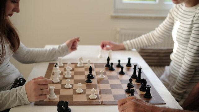 Family Playing Chess At Home And Moving Figures On The Board