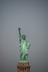 Fototapeta premium New york, usa august 16,2024. Statue of liberty against a gray sky, showing the iconic landmark and symbol of freedom and democracy in the united states