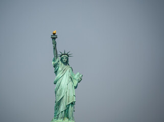 Fototapeta premium New york, usa august 16,2024. Statue of liberty on liberty island under an overcast sky, iconic symbol of freedom, democracy and welcome in the usa