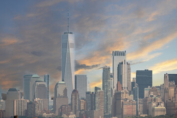 Naklejka premium New york, usa august 16,2024. One world trade center rising above the downtown manhattan skyline, capturing the urban landscape and modern architecture at sunset