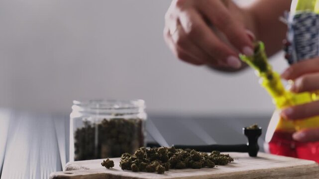 Girl Fills A Smoking Bong With Dry CBD Cannabis, Natural Preparations For Calming The Nervous System