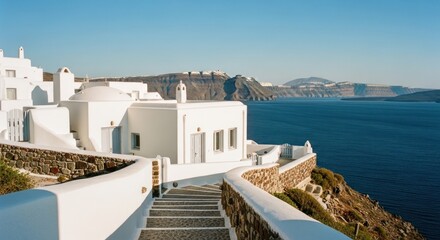 Obraz premium Whitewashed buildings cascade down a cliffside to a deep blue sea