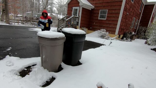 woman emptying the recycling trash in the backyard after the snow storm in February