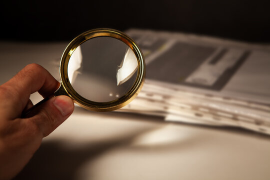 a man holds a magnifying glass and reads
