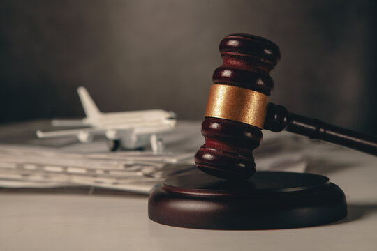 Wooden judge gavel and toy plane on table, law and justice concept