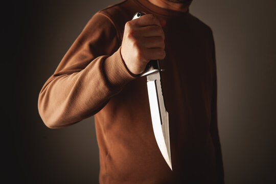 man with knife on dark background