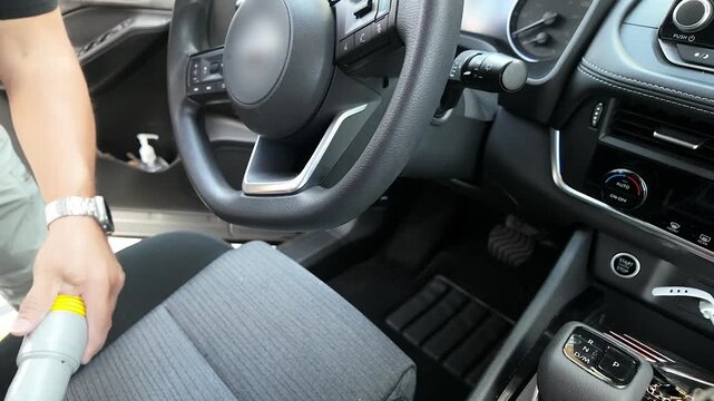vacuuming front seat and dashboard of car interior