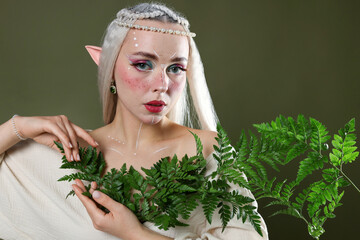 Naklejka premium Beautiful elf girl with floral decor on dark olive background
