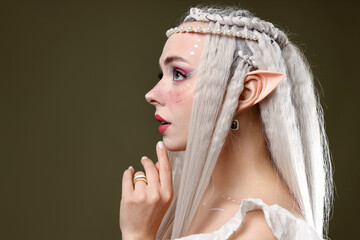 Naklejka premium Beautiful elf girl on dark olive background, space for text