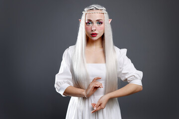 Naklejka premium Beautiful girl dressed as elf on grey background