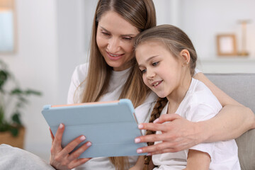 Obraz premium Mother and her daughter using tablet at home