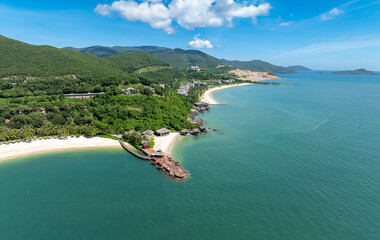Obraz premium An aerial view of a tropical resort with overwater bungalows and a white sand beach in on Hon Tre Island, Nha Trang, Vietnam. 