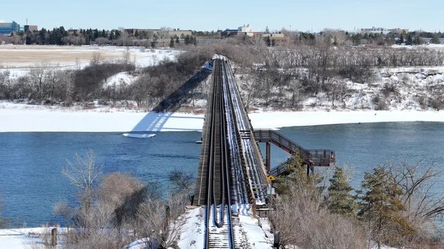 Aerial video shows the CPR bridge spanning a river in winter