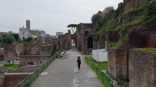 Tourist woman walk visiting ancient ruins of Roman Forum with aerial panoramic view