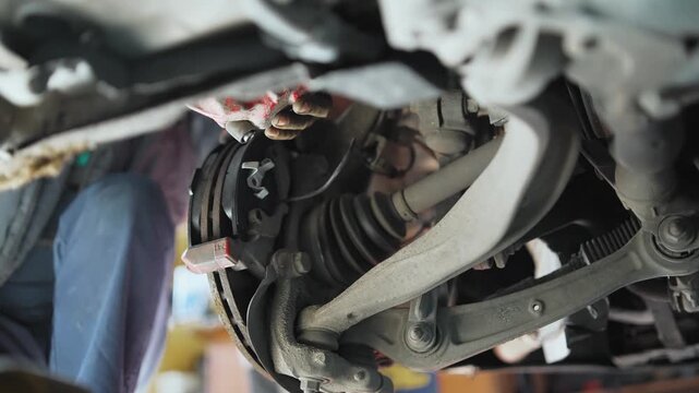 The disc brake of the car is being repaired, in the process of being replaced with new ones. Repair of car brakes in the garage. Vehicle suspension for servicing brakes