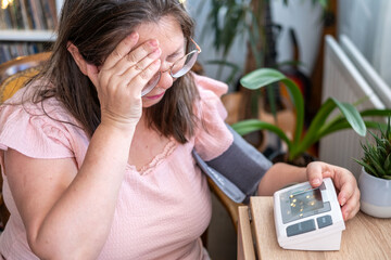 adult woman uses portable blood pressure monitor to track her health and pulse for wellness, wellness monitoring, portable device © kittyfly