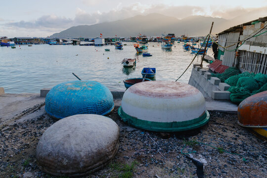 Traditional Vietnamese coracle boats are stored on the shore of a fishing village in Hon Mieu, Nha Trang, Vietnam. The boats are used by local fishermen for daily work.