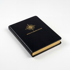 Obraz premium Sleek Black Leather Bound Notebook with Gold Foiling on the Cover Placed on a White Surface