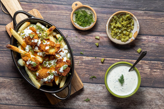 A dish filled with dill pickle poutine with dill pickle flavoured toppings.