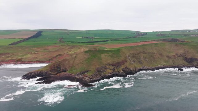 High angle aerial view of unique geological rock formations and coastal cliffs in Scotland.