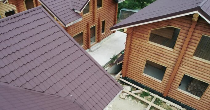 Building of wood house, a construction site of house scottages from timber logs, aerial view