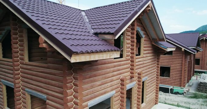 Building of wood house, a construction site of house scottages from timber logs, aerial view