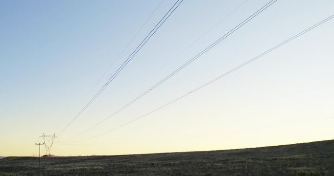 Distribution electric substation with power lines and transformers at sunset, sunrise