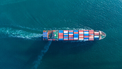 large cargo container ship fully loaded with colorful containers sailing through the deep blue ocean. Global maritime trade, freight transport and logistics business. © Yellow Boat