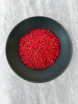 Pink peppercorns in a black bowl