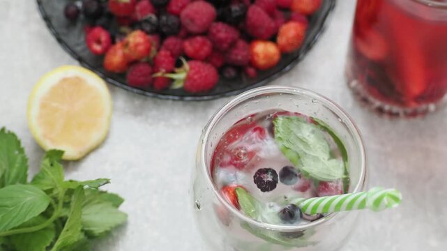 Summer drinks, colored cocktails on table. Lemonade, mojito, strawberry lemonade, tonic water. A refreshing summer drink with raspberries and blueberries, a detox drink for weight loss and keeping fit