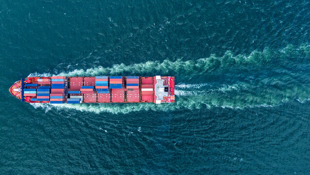large cargo container ship sailing in the deep blue ocean. Concept of global maritime logistics, international trade, and heavy shipping industry.