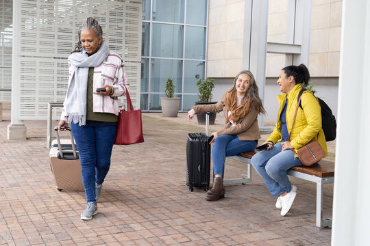 Senior woman tapping smartphone and walking, animated travel map showing itinerary guiding friends