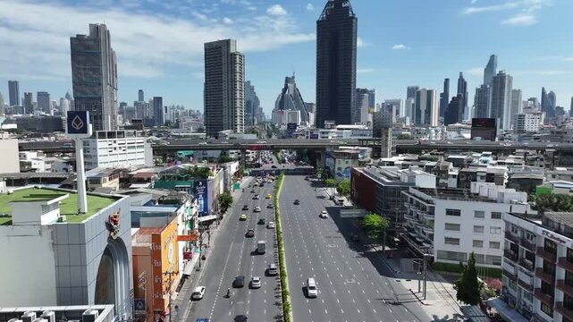 Rama 4 Road with vehicles moving along wide multilane street. Urban buildings and elevated road align with city transportation structure.
