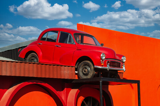 Vintage Red British Saloon Car Displayed on a Building Rooftop serving as a decorative landmark